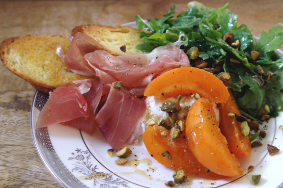 things on a plate: apricot, arugula, honey, pistachios, proscuitto.